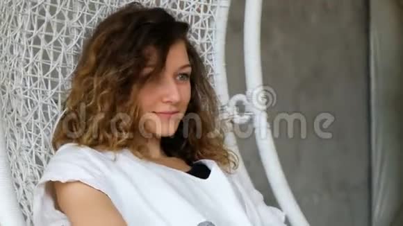 一个年轻的欧洲女孩在阁楼公寓的吊床上荡秋千美丽的女人在一个视频的预览图