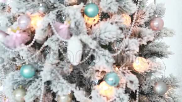 圣诞白雪覆盖的圣诞树特写上面有球锥和珠子上面有明亮的花环和灯光视频的预览图