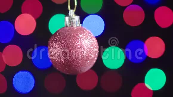 圣诞红球玩具正在旋转特写装饰与新年树灯闪烁的背景视频的预览图