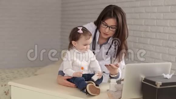 女儿科医生在医院里和一个小孩玩视频的预览图