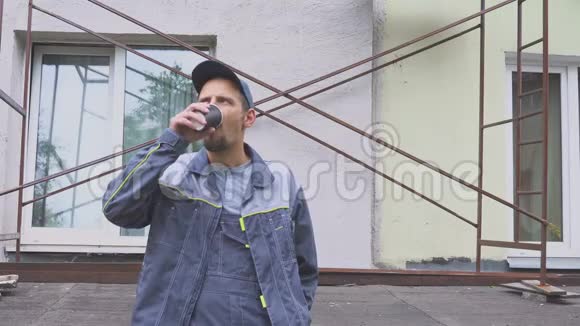 建筑工人或建筑工人在建筑附近享受一杯咖啡视频的预览图