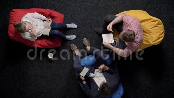三个工人坐在沙发上放松交谈办公室观念交流观念视频的预览图