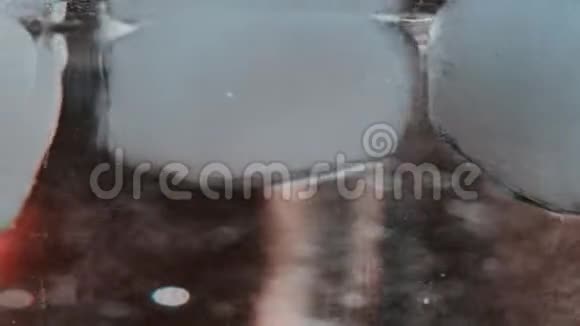 在玻璃杯中旋转的冰块的宏镜头视频的预览图