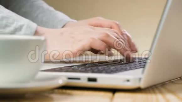 一位漂亮的女商人正坐在一张桌子旁手里拿着一台笔记本电脑在咖啡馆工作视频的预览图