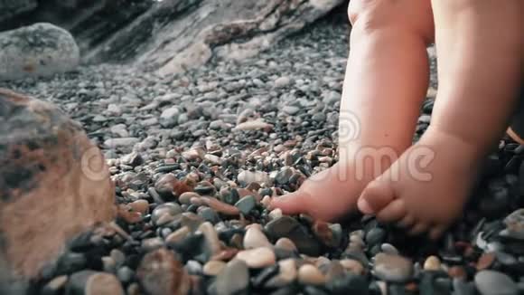 宝贝光着脚在鹅卵石滩上特写镜头视频的预览图