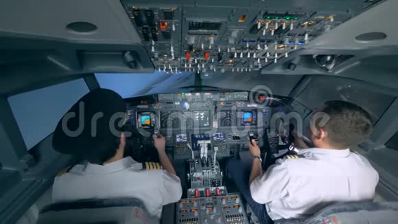 两名飞行员在飞行模拟器中驾驶飞机视频的预览图