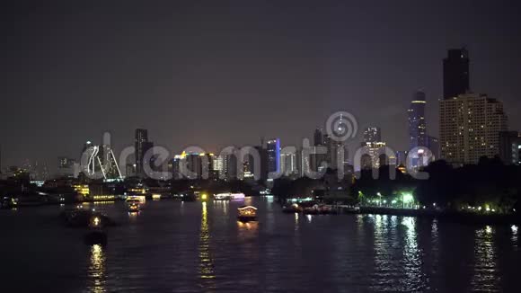 城市天际线上夜晚的现代建筑灯光以及沿河航行的船只视频的预览图