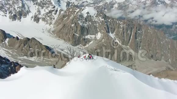 阳光明媚的一天雪山峰上的人们鸟瞰图视频的预览图