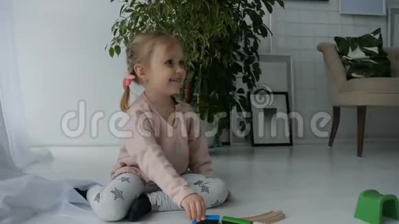 可爱的小女孩玩木铁路视频的预览图