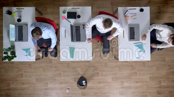 三个年轻的商人在工作场所玩扔纸游戏休息观念办公室观念沟通观念顶级射击视频的预览图