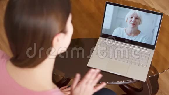 女儿在国外学习通过信使应用程序与她的高级母亲在笔记本电脑上进行视频聊天视频的预览图