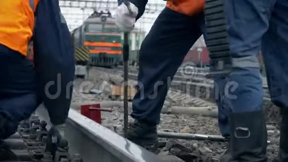 铁路工人在工作铁路线上穿橙色制服的铁路工人视频的预览图