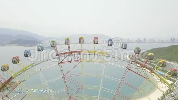 海上游乐园摩天轮山地和现代城市景观带大型摩天轮的空中观光游乐园视频的预览图