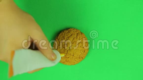 孩子在饼干美元标志上画了一块绿色背景的棕色糖霜时光飞逝手工制作视频的预览图