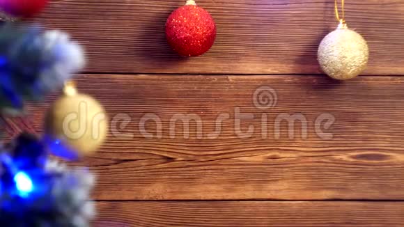 木制圣诞背景不同颜色的圣诞球和圣诞树上的圣诞灯视频的预览图