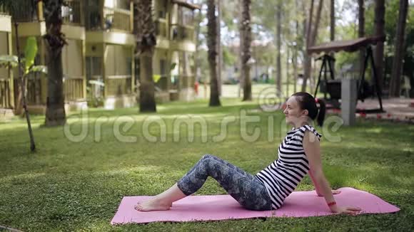 妈妈和女儿在公园的草坪上健身视频的预览图