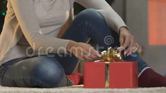 女人在大礼盒上拉直弓准备圣诞礼物视频的预览图