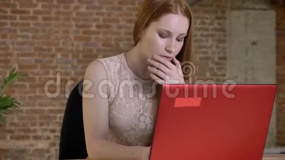 年轻可爱的姜姑娘在办公室里用笔记本电脑工作工作观念商业观念交流观念视频的预览图