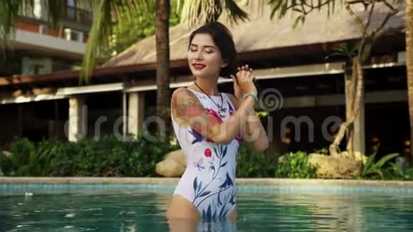 在酒店游泳池摆姿势的女人视频的预览图