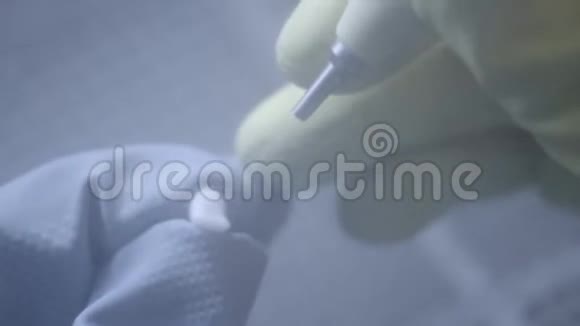 牙科技师在牙科实验室使用砂光机抛光人造陶瓷牙齿专业人士戴手套手提视频的预览图