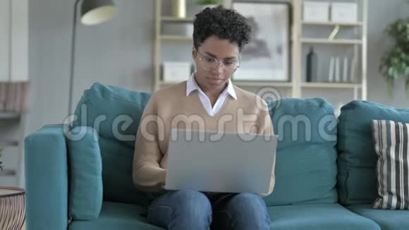 开朗的非洲女孩在笔记本电脑上工作视频的预览图