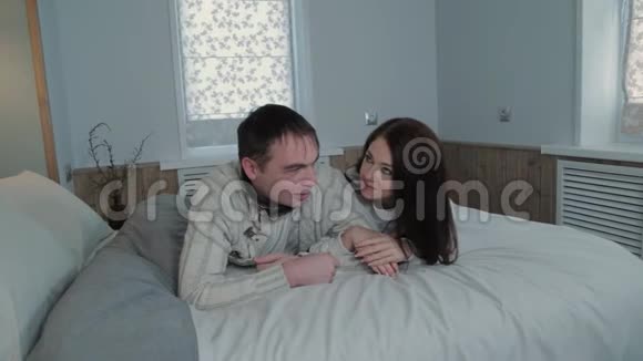 美丽的年轻情侣在床上的现代室内视频的预览图