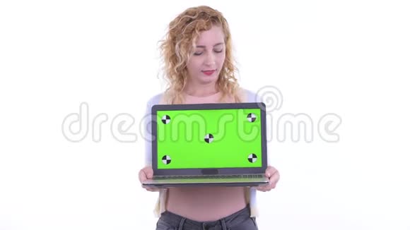 一位美丽的金发美女一边说一边展示笔记本电脑视频的预览图