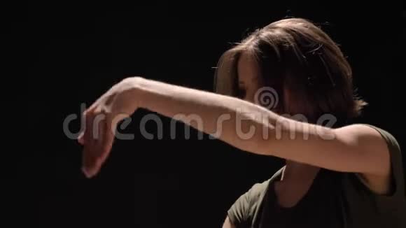 年轻迷人的女孩手舞足蹈看镜头黑色背景芭蕾概念动作概念视频的预览图