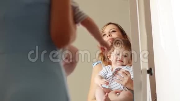 妈妈和镜子旁边的一个小孩视频的预览图