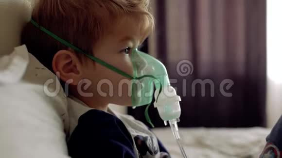 男孩透过吸入器的透明面罩呼吸那男孩自己做的脸上的吸入式面罩视频的预览图