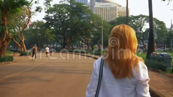 迷人的年轻女人金色的头发在市中心冲来冲去视频的预览图