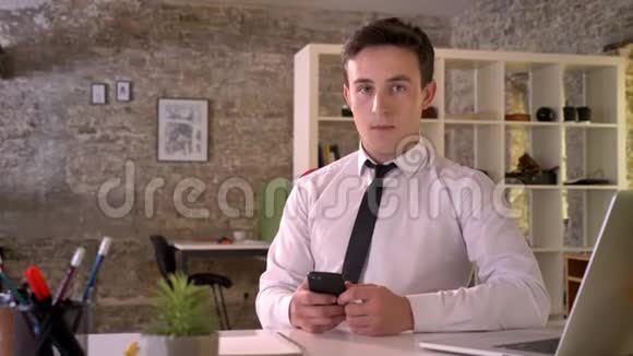 年轻有魅力的商人正在办公室工作智能手机显示绿色屏幕指出它的商业概念视频的预览图