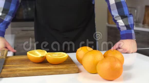 厨房里穿围裙的男人桌子上摆着橘子健康的食物饮食慢节奏生活方式视频的预览图