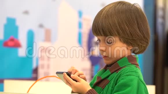 可爱的小男孩使用智能手机机器人在第四届俄罗斯科学节为孩子们演示活动的目的是视频的预览图