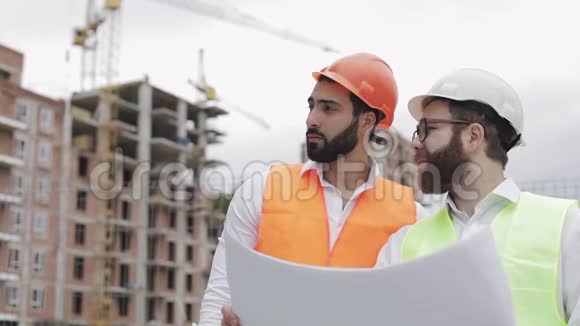 高层建筑施工现场或建筑工地男建筑工程师与建筑师讨论他们视频的预览图
