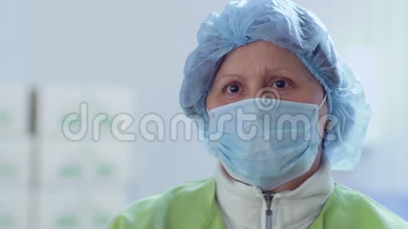 女人从脸上摘下防护面罩工厂工人视频的预览图