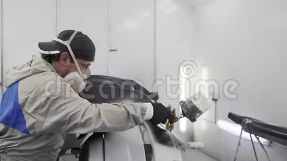 人类正在汽车服务的喷漆室中绘制汽车零部件视频的预览图