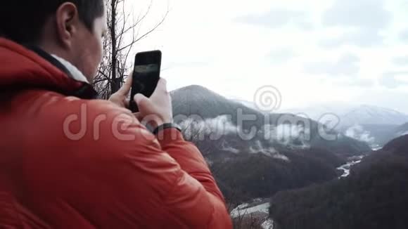 冬季夹克的成人游客拍摄美丽的山景视频的预览图