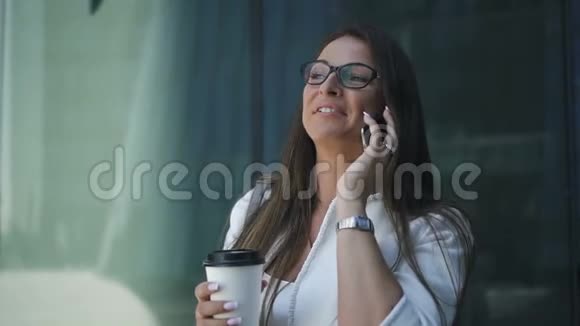 成功的女商人正在打电话拿着咖啡杯在户外视频的预览图