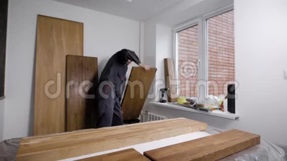 木工正在一个小木工车间的桌子上放木材板准备加工视频的预览图