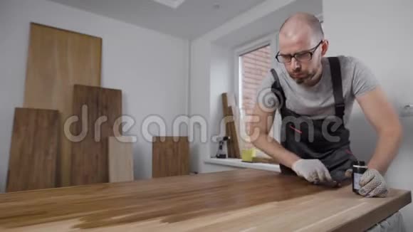 成年男子在家里的一个房间里用清漆木工和家具木工和家具组装视频的预览图