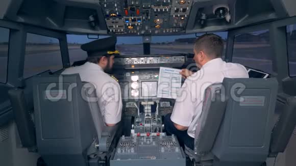 飞行员在飞行模拟器的驾驶舱里读手册4K视频的预览图