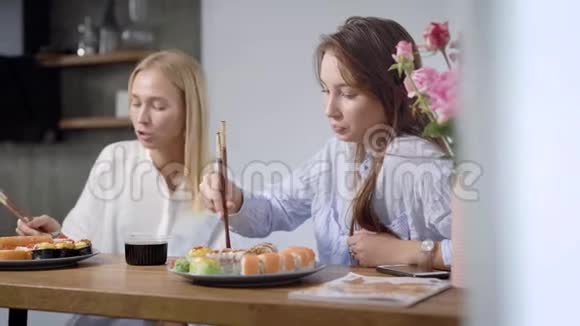 两个漂亮的女孩在家吃日本菜卷在盘子上是不同的非常好吃视频的预览图