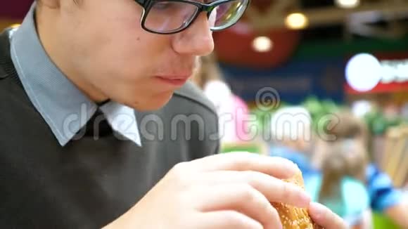 一个年轻人正在购物中心吃汉堡包视频的预览图