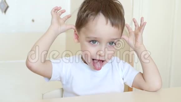 一个孩子的特写镜头以一种缓慢的速度看着微笑着孩子拉皮条露出角舌头和一个视频的预览图