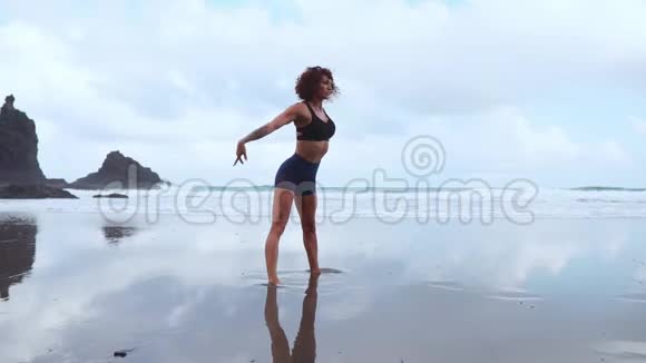 这个女孩一大早在海滨做运动前先做热身运动一个身材魁梧的女孩视频的预览图