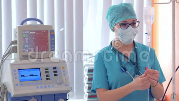 一位女医生正在给一个滴瓶接线并在监视器上设定参数视频的预览图