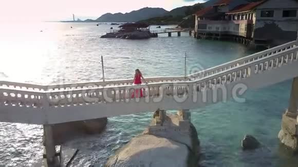穿红衣服的女人站在白桥全景视频的预览图