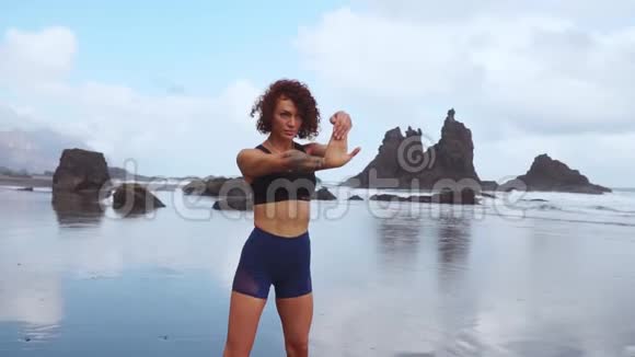 健身和动力健康的运动员女孩在阳光明媚的日子在海滩上伸展带辫子的运动型女性视频的预览图