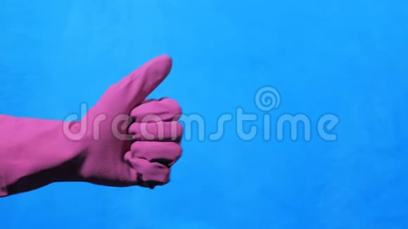 干净的手在蓝色背景上的紫色橡胶手套喜欢和不喜欢的手势视频的预览图